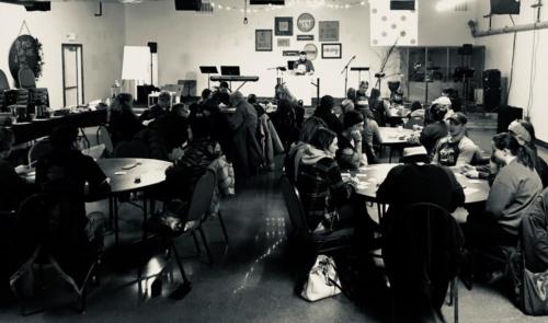 A large group gathered around round tables.